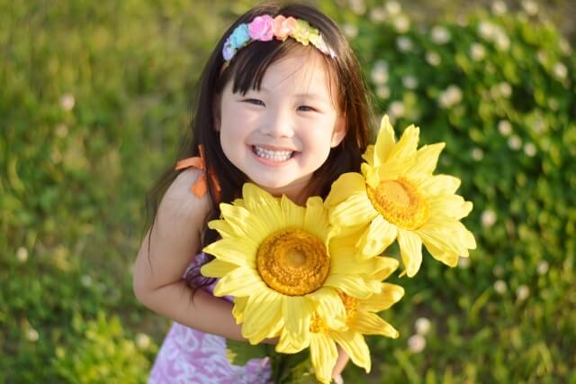「子ども好きな人」からお花をプレゼントされて喜ぶ笑顔の女の子